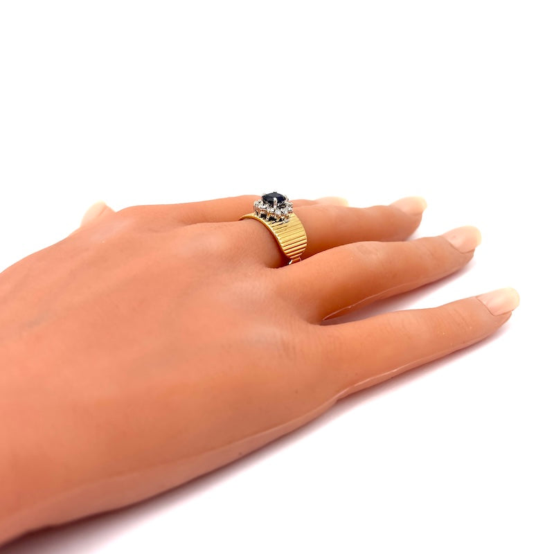 Anello a fascia scanalata oro giallo, con margherita zaffiro e brillanti; 7.76 gr